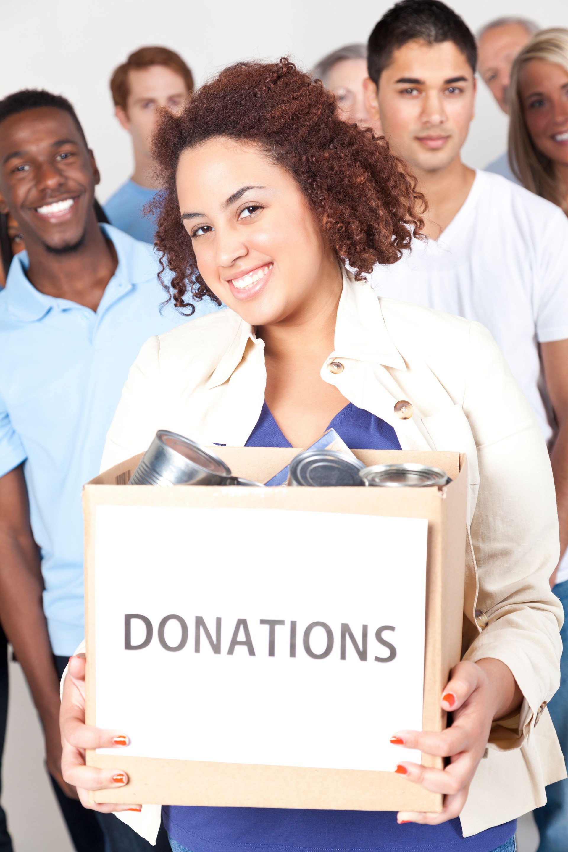 Diverse group of young volunteers holding donations; studio shot