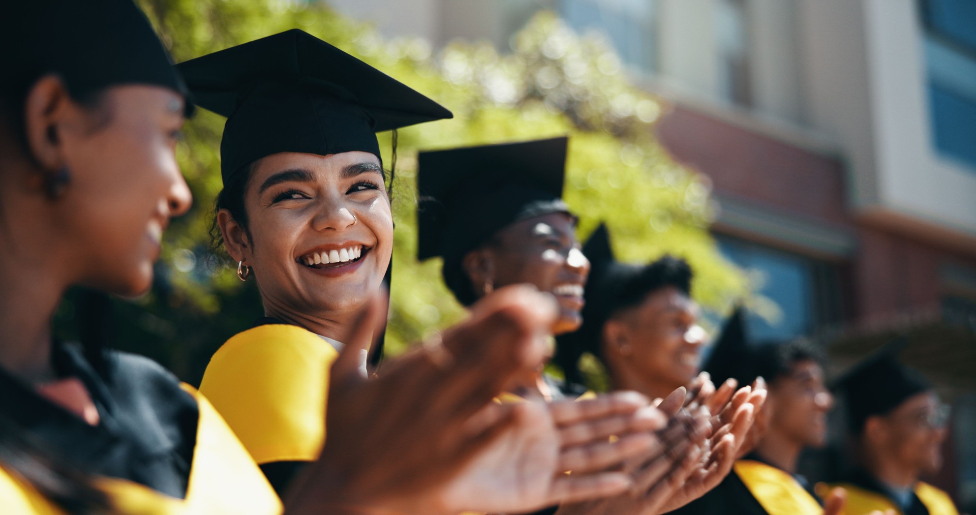 People, students and applause at university for graduation, peer support and happy for achievement. Class, clapping and outdoor on campus for academic success, pride and smile for education milestone